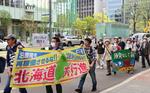 　原発の再稼働反対などを訴える横断幕を手に行進する参加者＝５日午後、札幌市
