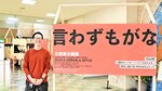 巨大ポスターと並び、企画展開催をアピールする森田さん＝三朝町総合文化ホール
