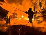 　ウクライナ東部ハリコフのロシア軍による無人機攻撃を受けた現場で消火作業に当たる消防士＝４日（ロイター＝共同）