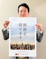 マイクロＭ＆Ａ士協会のポスターを持つ都鍾洵代表（同協会提供）
