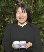 　開発中の岩ガキの缶詰を手に持つ西野春華さん＝２０２４年３月、島根県西ノ島町