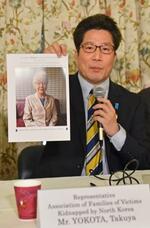 　記者会見で横田早紀江さんの写真を見せる拉致被害者家族会代表の拓也さん＝４月３０日、ワシントン（共同）