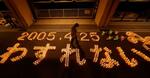 　尼崎ＪＲ脱線事故から１９年となるのを前に、追悼行事でともされたろうそくで浮かび上がった「２００５・４・２５　わすれない」の文字＝２４日夜、兵庫県尼崎市