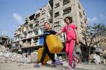 　イスラエル軍の攻撃で破壊された建物近くを歩く子どもたち＝１日、ガザ地区南部ラファ（ロイター＝共同）