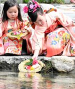 無病息災を願い、流しびなを見送る女の子＝１１日、鳥取市用瀬町の千代川