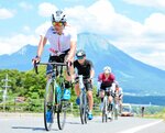 雄大な大山を背にペダルをこぐ選手たち＝１６日、鳥取県米子市東八幡