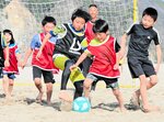 砂の上でボールを追う子どもたち＝２９日、新温泉町芦屋の浜坂県民サンビーチ