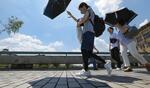 　昨年７月、厳しい暑さの中、京都市内を日傘を差して歩く人たち