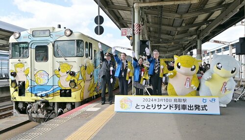 サンドやアローラサンドがデザインされたラッピング列車の出発を見送る平井知事（左から２人目）ら＝１０日、ＪＲ鳥取駅
