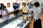  学芸員（右）の解説を聞きながら作品を鑑賞する来館者ら＝２８日、倉吉博物館 