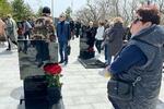 　ウクライナ侵攻で戦死した息子ニキータ・リャミンさんの墓の前に立つ母マリーナさん（右端）＝２５日、ロシア・ウラジオストク（共同）