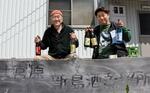 　ＧＩ指定された焼酎を従業員（右）とＰＲする宮原淳さん＝３月、東京都新島村
