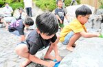 露天風呂の清掃作業に挑戦する子どもたち＝６日、三朝町山田の三朝館