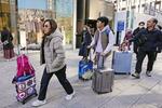 　東京・銀座でスーツケースを手に歩く外国人ら＝１月