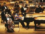　東京・サントリーホールのステージで堤剛さん（左前）の演奏を聴く小澤征爾さん（右）＝１９９５年１月（（Ｃ）サントリーホール）