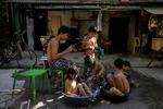 　４月２９日、猛暑に見舞われたフィリピン・マニラでバケツや洗面器につかる子どもたち（ロイター＝共同）