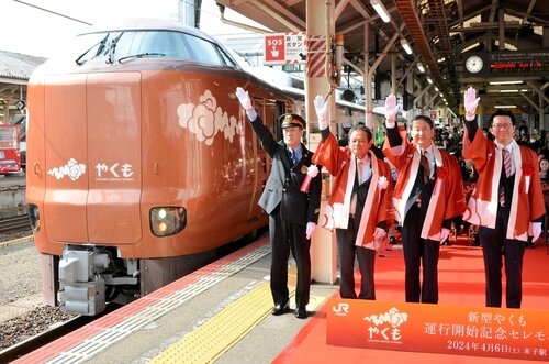 特急やくもの新型車両の出発合図をする平井知事（左から３人目）ら関係者＝６日、ＪＲ米子駅