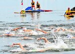水しぶきを上げながら力泳する参加者ら＝２５日、米子市西町の湊山公園沖の中海