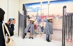 かさやマントを着けて広重の作品と一緒に写真撮影を楽しむ親子＝１５日、米子市美術館