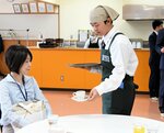 客役の女性にコーヒーを提供する生徒