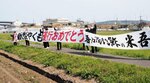 激　励　
新型「やくも」の運行を祝し、ＪＲ伯備線沿線では横断幕を掲げる人たちの姿があった＝６日、米子市赤井手