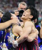 　男子団体総合決勝　鉄棒の演技を終え、萱和磨（左）と抱き合う橋本大輝＝パリ（共同）