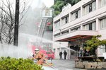 一斉放水を行う消防隊員や施設の職員＝４日、新温泉町歌長の特別養護老人ホームゆむら