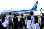 着陸し地上走行する機体を写真に収める参加者