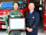勤務中に的確な水難救助で人命を救い、平田署長（右）から表彰を受けた谷口さん＝２２日、鳥取市湖山町北４丁目の湖山消防署