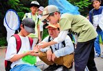 鶴さん（中央）と一緒に見つけた虫の名前や特徴を確認する部員たち＝２２日、倉吉市の打吹公園