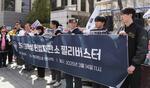 　韓国憲法裁の前で大統領の尹錫悦の弾劾に反対する男子学生ら＝３月、ソウル（共同）