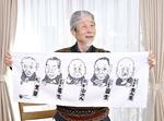 　往年の落語家の似顔絵を持つ針すなおさん