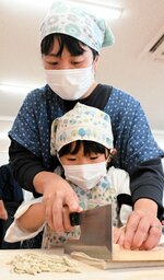 集中して生地を細く切る参加者ら