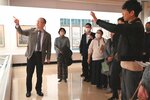 展示作品を見て自分の考えを話し合う三沢教授（左）と参加者ら＝１１日、鳥取市の鳥取県立博物館