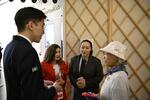 　カザフスタンブースで館長（左から２人目の赤い服の女性）にあいさつされる山田外美代さん＝４月２１日、大阪市此花区