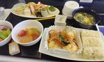 行きの機内で提供された昼食の和食メニュー。どれもとてもおいしかった。みそ汁の左に置かれているのが「はちみつまんじゅう」