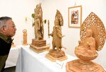 表情豊かな仏像彫刻を鑑賞する来場者