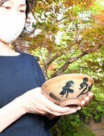 菅楯彦が絵付けを施した茶わん。実際に使用して抹茶の振る舞いが行われている＝９日、倉吉市河原町の小川氏庭園環翠園