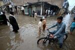 　パキスタン北西部ペシャワルで冠水した道路を歩く人々＝１５日（ＡＰ＝共同）