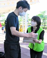 帰省客らにチラシやパンフレットなどのセットを手渡す職員（右）＝１２日、鳥取市の鳥取砂丘コナン空港