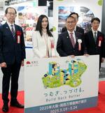 　「東日本大震災からのよりよい復興」の開会式典で、記念写真に納まる荒川静香さん（左から２人目）ら＝１９日午前、大阪市此花区の夢洲