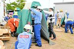 マンホールにトイレ用の便座やテントを取り付ける訓練をする参加者＝６日、養父市八鹿町の道の駅ようか但馬蔵