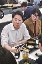 　ソウルの延世大の学生食堂で学生らと食事する野党「改革新党」の李俊錫議員（左）＝１２日（共同）