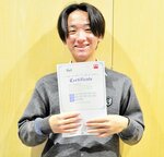  合格証明書を手に笑顔を見せる徳倉さん 