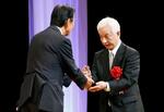 　第７３回全日本広告連盟福井大会で「正力賞」を受賞した河北新報社の一力雅彦社長（右）＝１５日午後、福井市