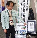 　ギネス世界記録の認定証を指さす神山修二さん＝３月、静岡県長泉町