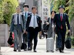 　大阪地裁に向かうプレサンスコーポレーションの山岸忍元社長（中央）ら＝１１日午前９時３１分