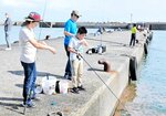 大物を狙って釣り糸を垂らす家族＝９日、新温泉町芦屋の浜坂漁港