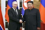 　会談前に握手するロシアのプーチン大統領（左）と北朝鮮の金正恩朝鮮労働党総書記＝６月、平壌（ＡＰ＝共同）