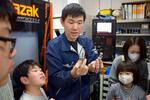 　加工した金属部品をみせる石山ネジの担当者＝３月、横浜市港北区